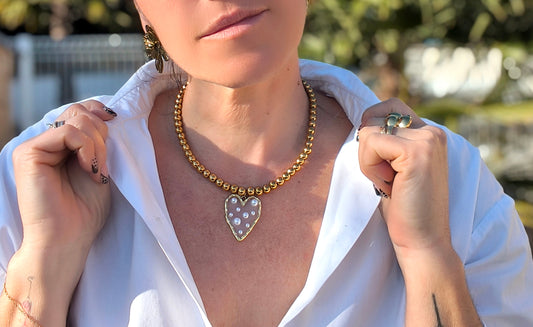 Femme portant Collier perles dorées avec pendentif cœur transparent avec perles blanches - Rêve de Rose