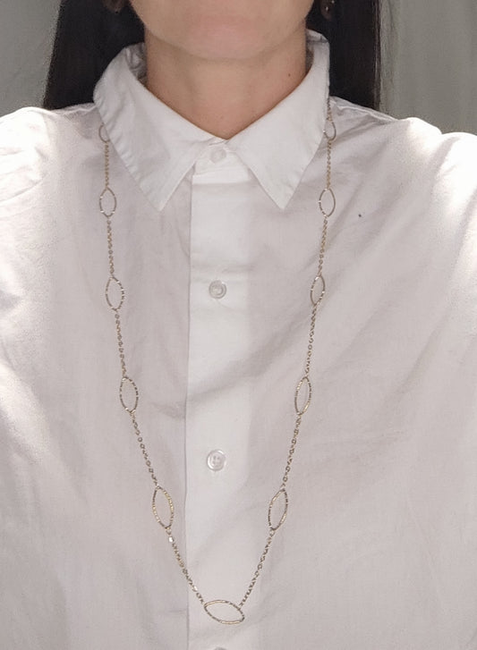 Femme portant un collier sautoir doré avec alternance de maillons fins et de maillons ovales - Rêve de Rose