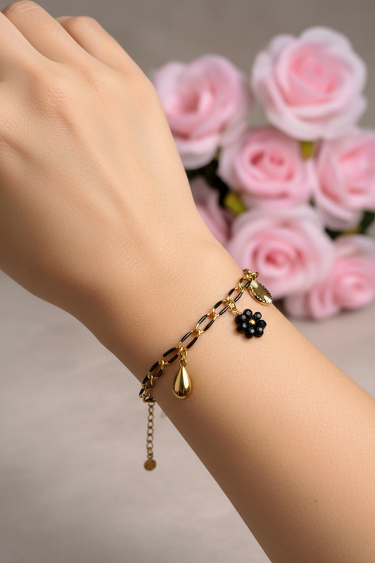 Femme portant un bracelet chaîne noire et dorée avec charm fleur noire et 2 charms dorés - Rêve de Rose