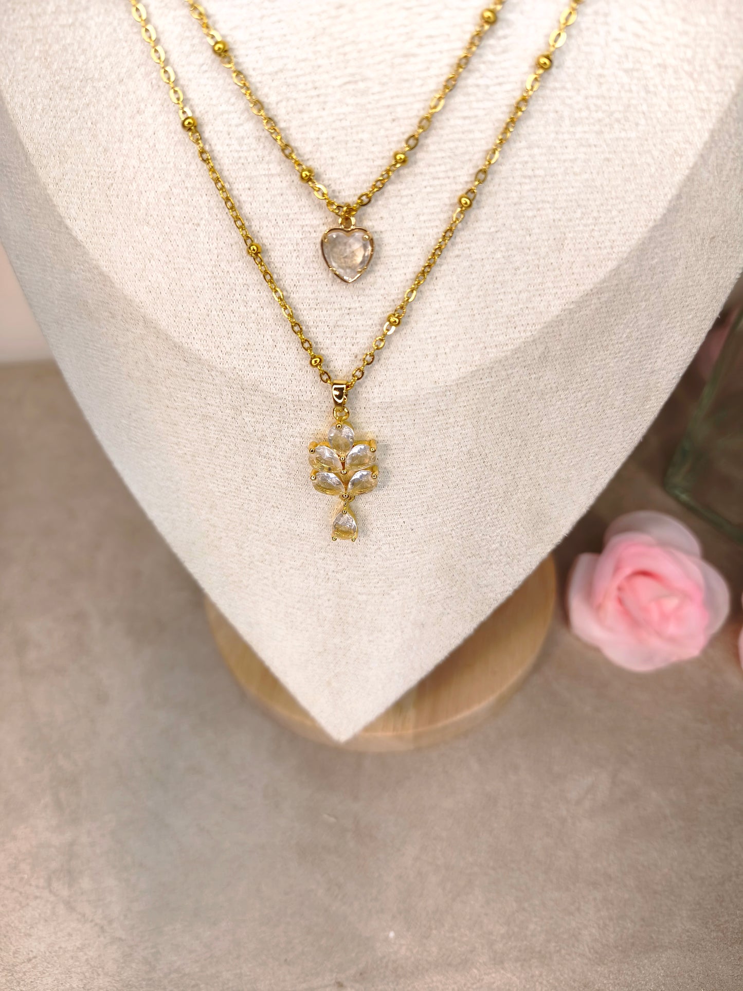 Zoom sur un collier double chaîne avec une cœur scintillant et une fleur scintillante - Rêve de Rose