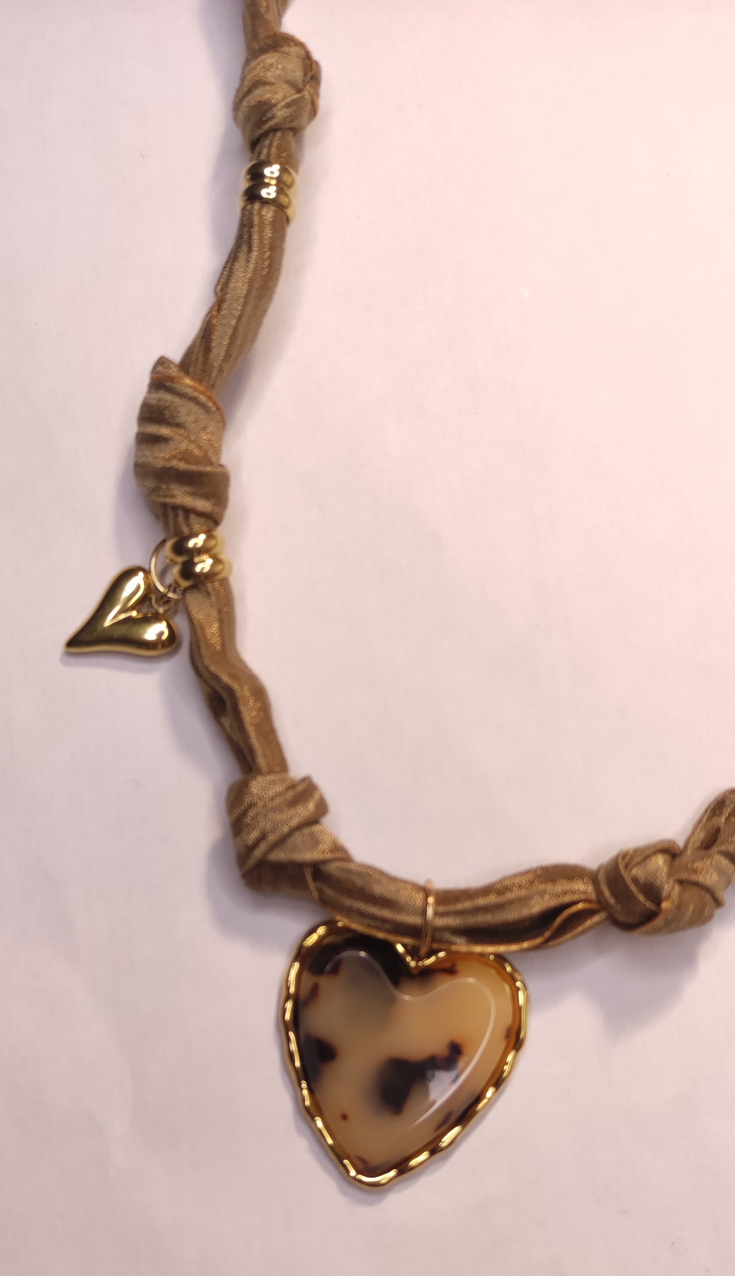 Détail d'un collier en tissu satiné beige avec un pendentif gros cœur léopard et 2 cœurs dorés - Rêve de Rose