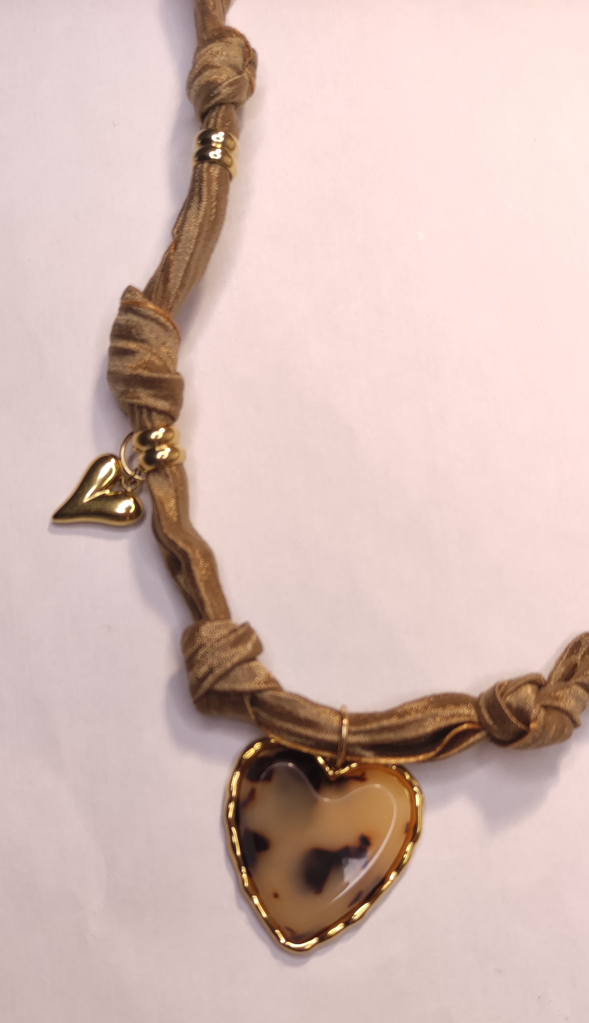 Détail d'un collier en tissu satiné beige avec un pendentif gros cœur léopard et 2 cœurs dorés - Rêve de Rose