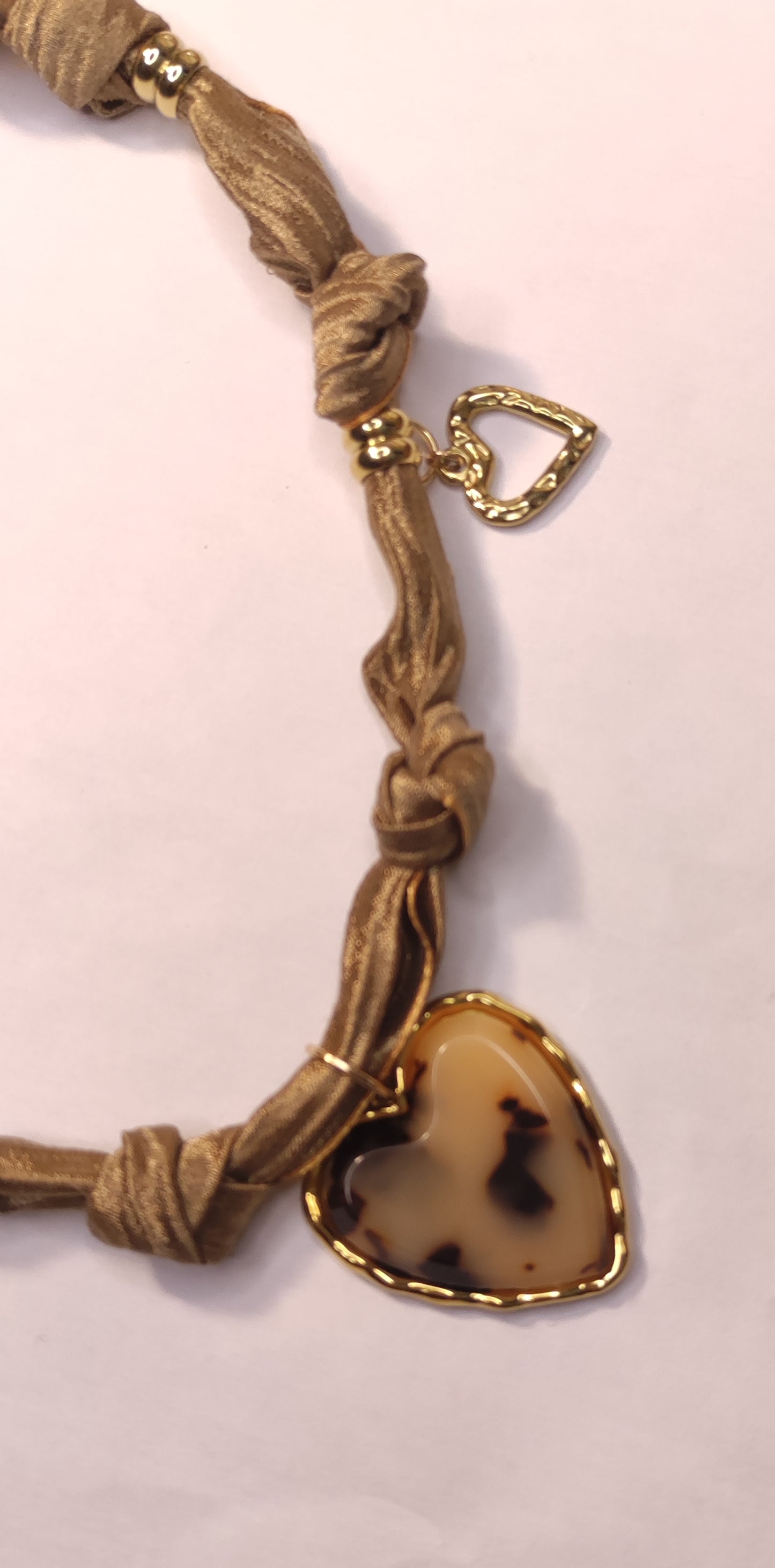 Détail d'un collier en tissu satiné beige avec un pendentif gros cœur léopard et 2 cœurs dorés - Rêve de Rose
