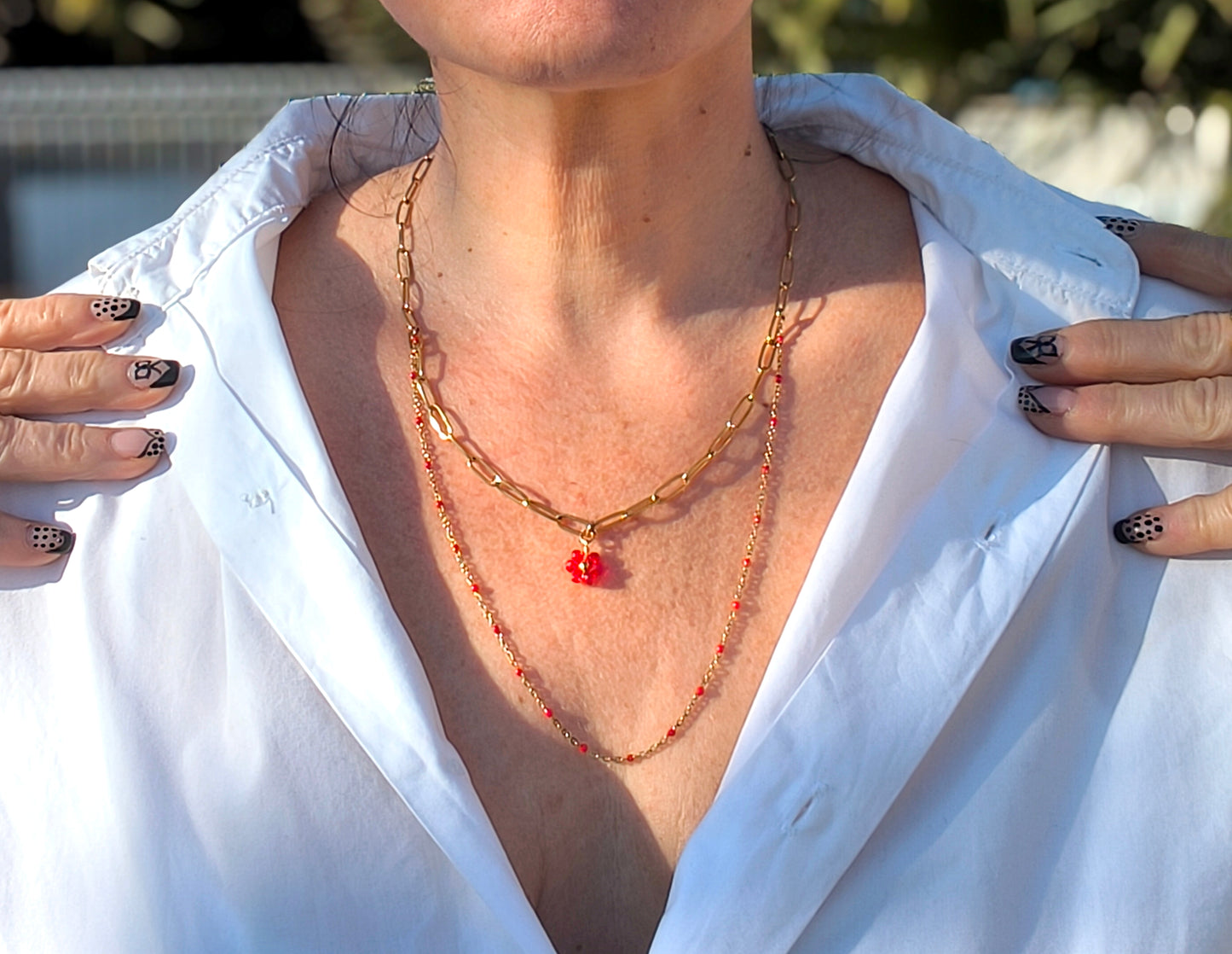 Femme portant collier double chaînes dorées perles rouges fleur - Rêve de Rose