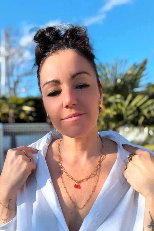 Femme portant collier double chaînes dorées perles rouges fleur - Rêve de Rose