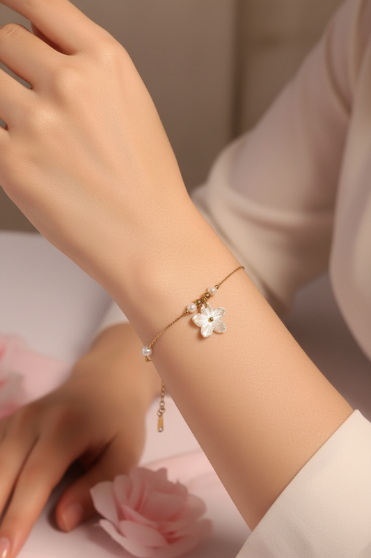 Femme portant un bracelet fin doré avec des perles blanches et une fleur blanche - Rêve de Rose