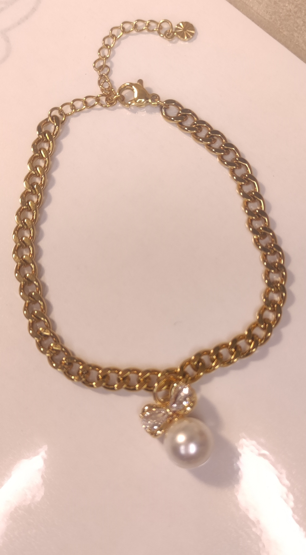 Détail bracelet au maillons serrés avec pendentif nœud et perle blanche - Rêve de Rose