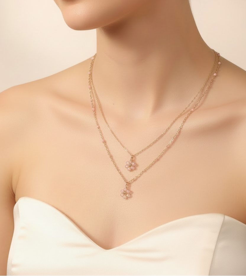 Femme portant un collier double chaîne fine avec 2 pendentifs fleur en perles rose pastel - Rêve de Rose