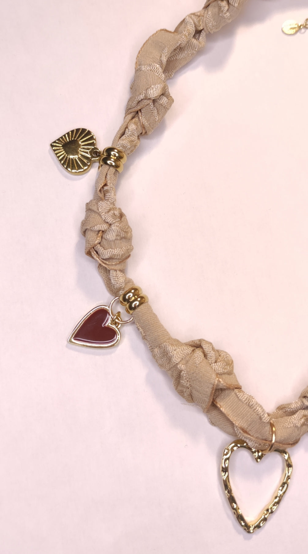 Détail d'un collier tissu beige avec 5 charms cœurs marrons et dorés - Rêve de Rose