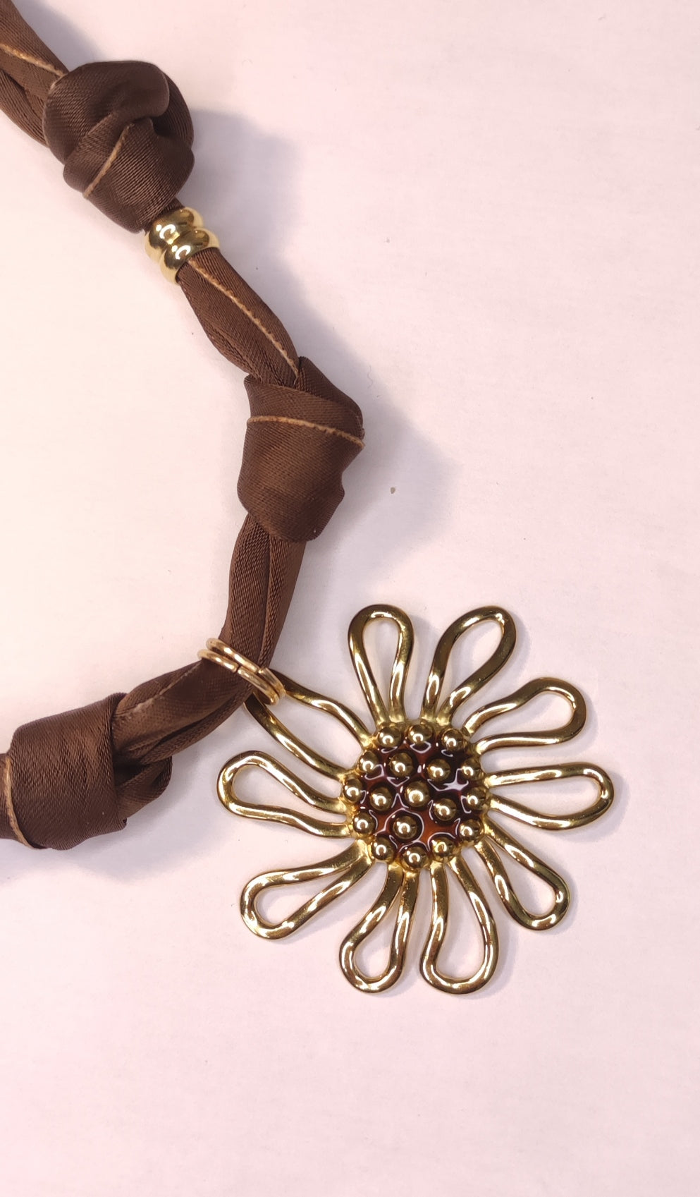 Détail d'un collier en tissu marron avec gros pendentif fleur dorée - Rêve de Rose