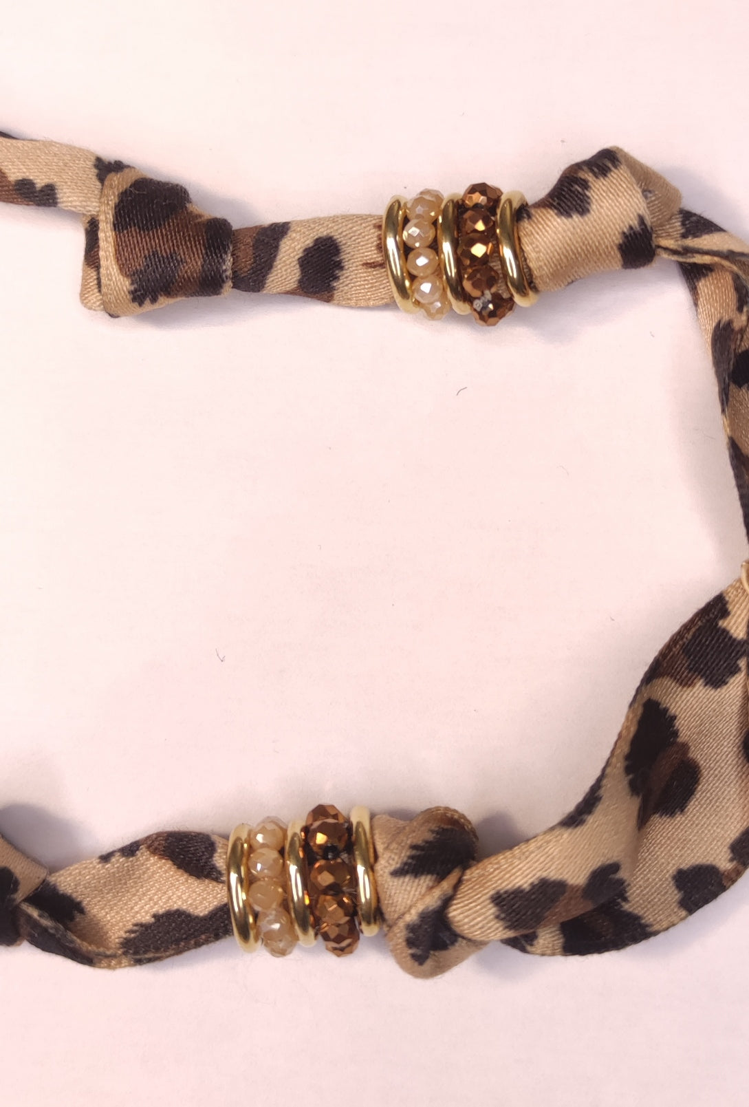 Détail d'un collier tissu léopard avec pendentif fleur marron en résine - Rêve de Rose