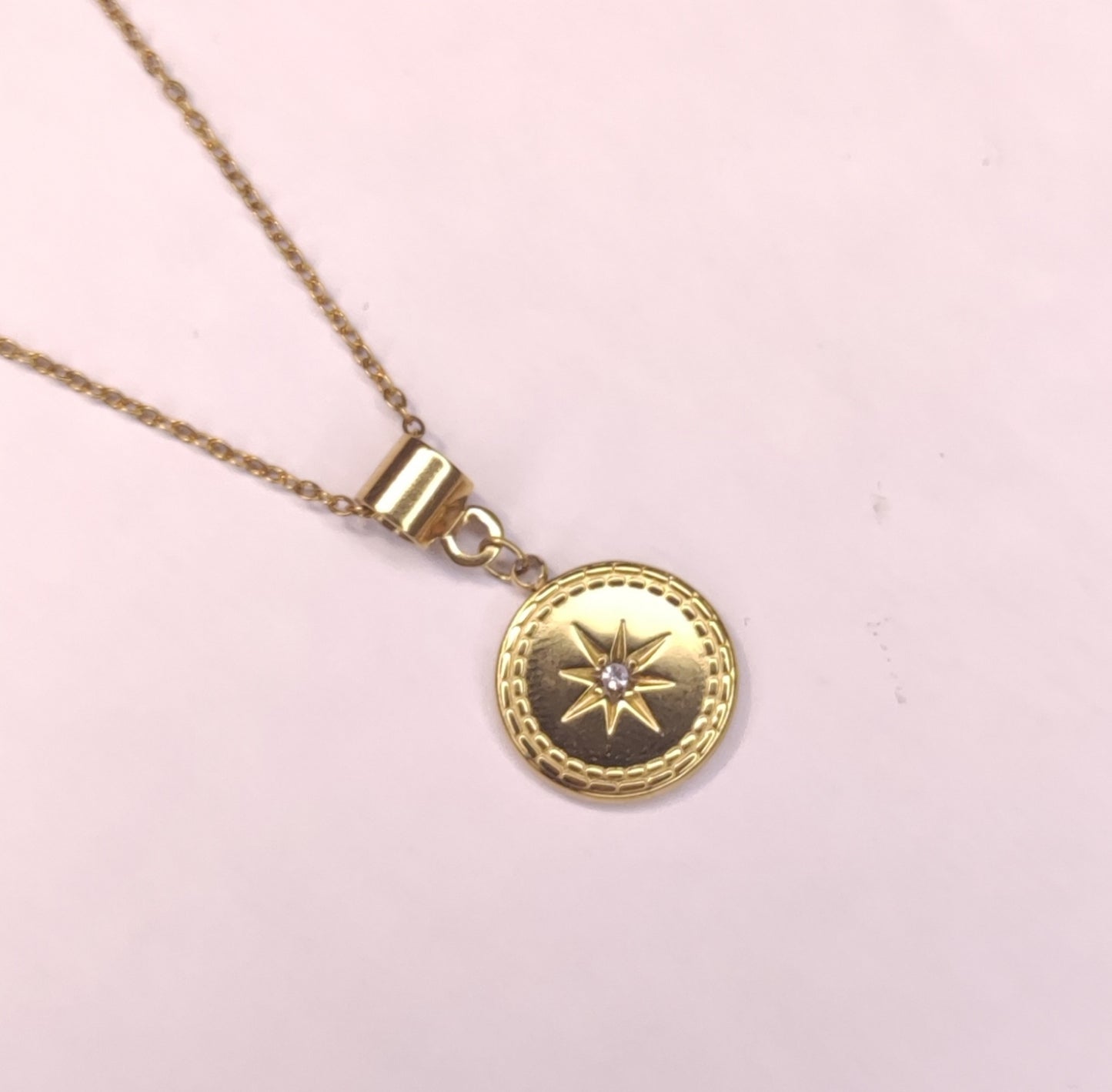 Détail d'un collier triple chaîne avec petites perles dorées pendantes, un pendentif pierre scintillante et un pendentif rond avec une étoile scintillante - Rêve de Rose 