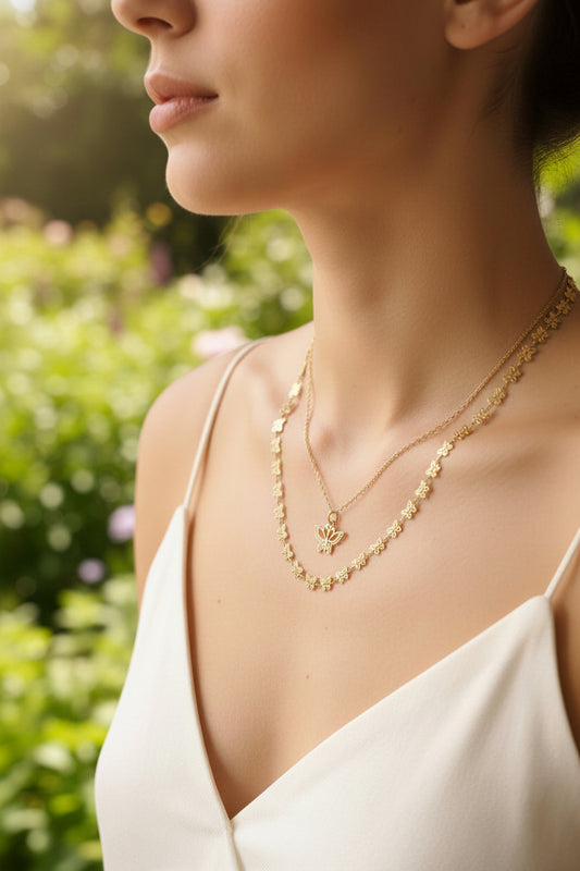 Femme portant un collier double chaîne doré une fine et une sertie de papillons avec un pendentif papillon doré - Rêve de Rose 