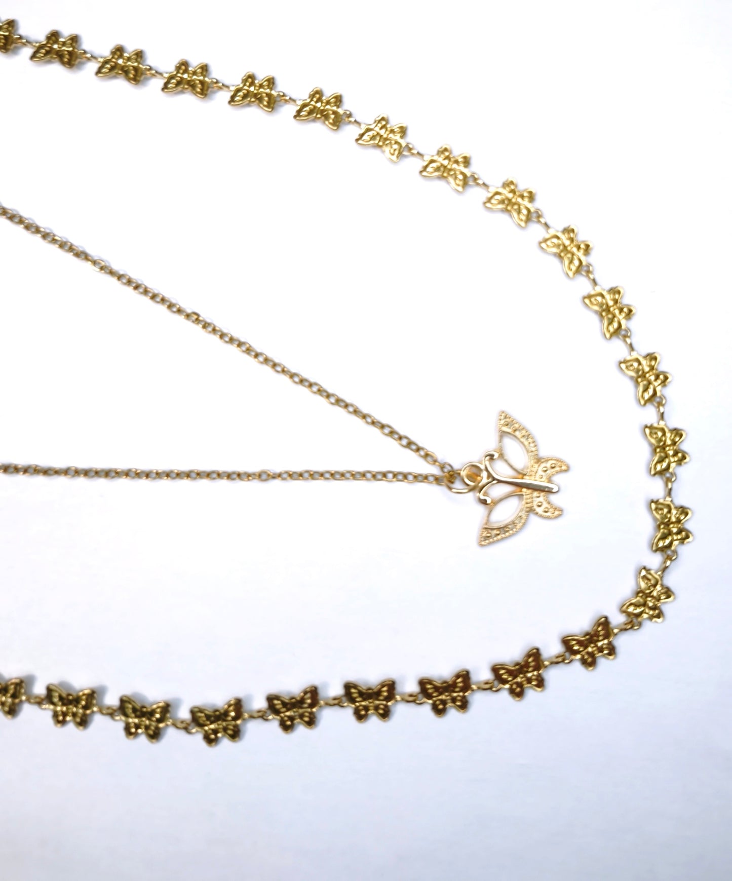 Détail d'un collier double chaîne doré une fine et une sertie de papillons avec un pendentif papillon doré - Rêve de Rose 