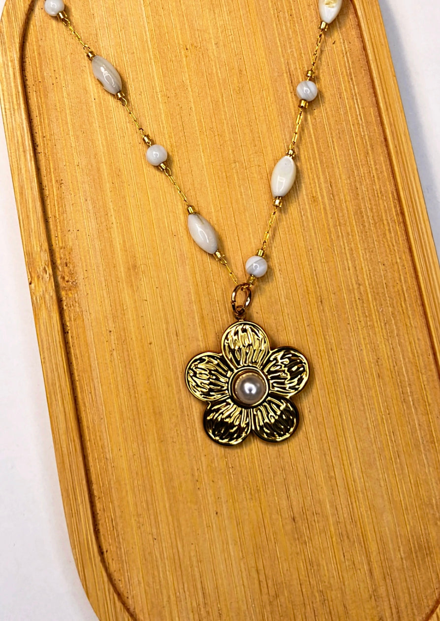 Détail d'un collier chaîne dorée avec des perles blanches avec un pendentif fleur dorée - Rêve de Rose