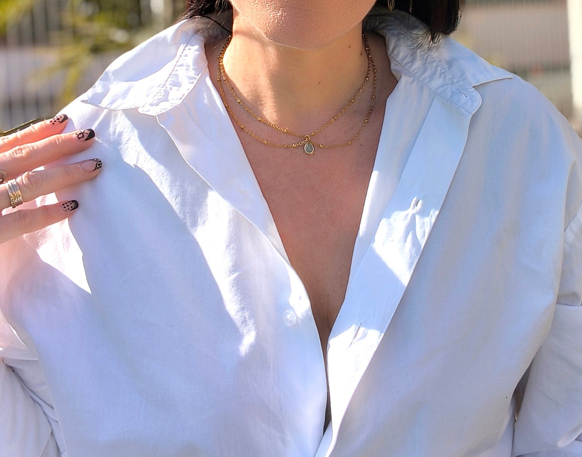 Femme portant Collier double chaîne dorée avec pendentif pierre verte pastel au centre - Rêve de Rose