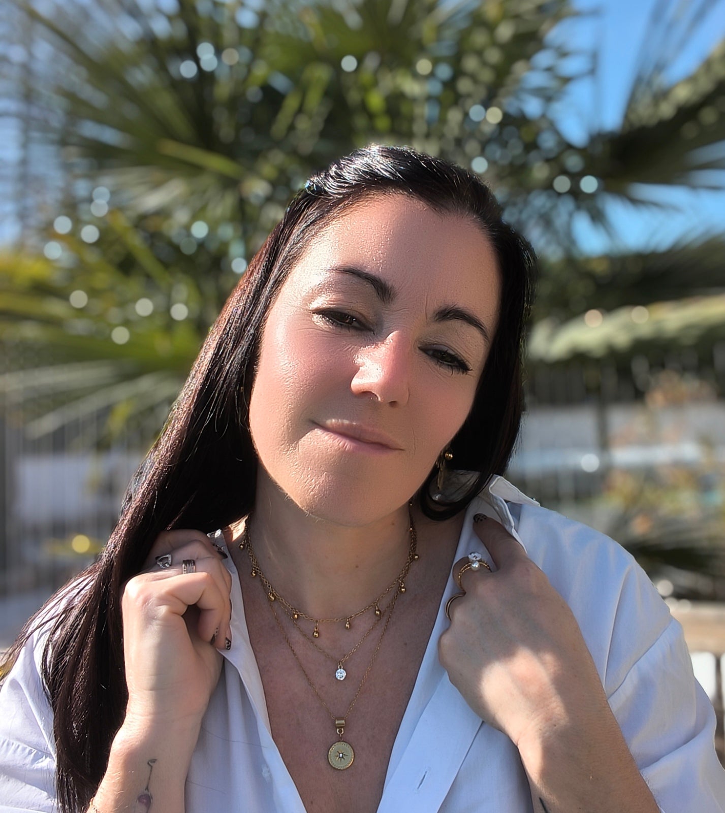 Femme portant Collier triple chaîne avec petites perles dorées pendantes, un pendentif pierre scintillante et un pendentif rond avec une étoile scintillante - Rêve de Rose