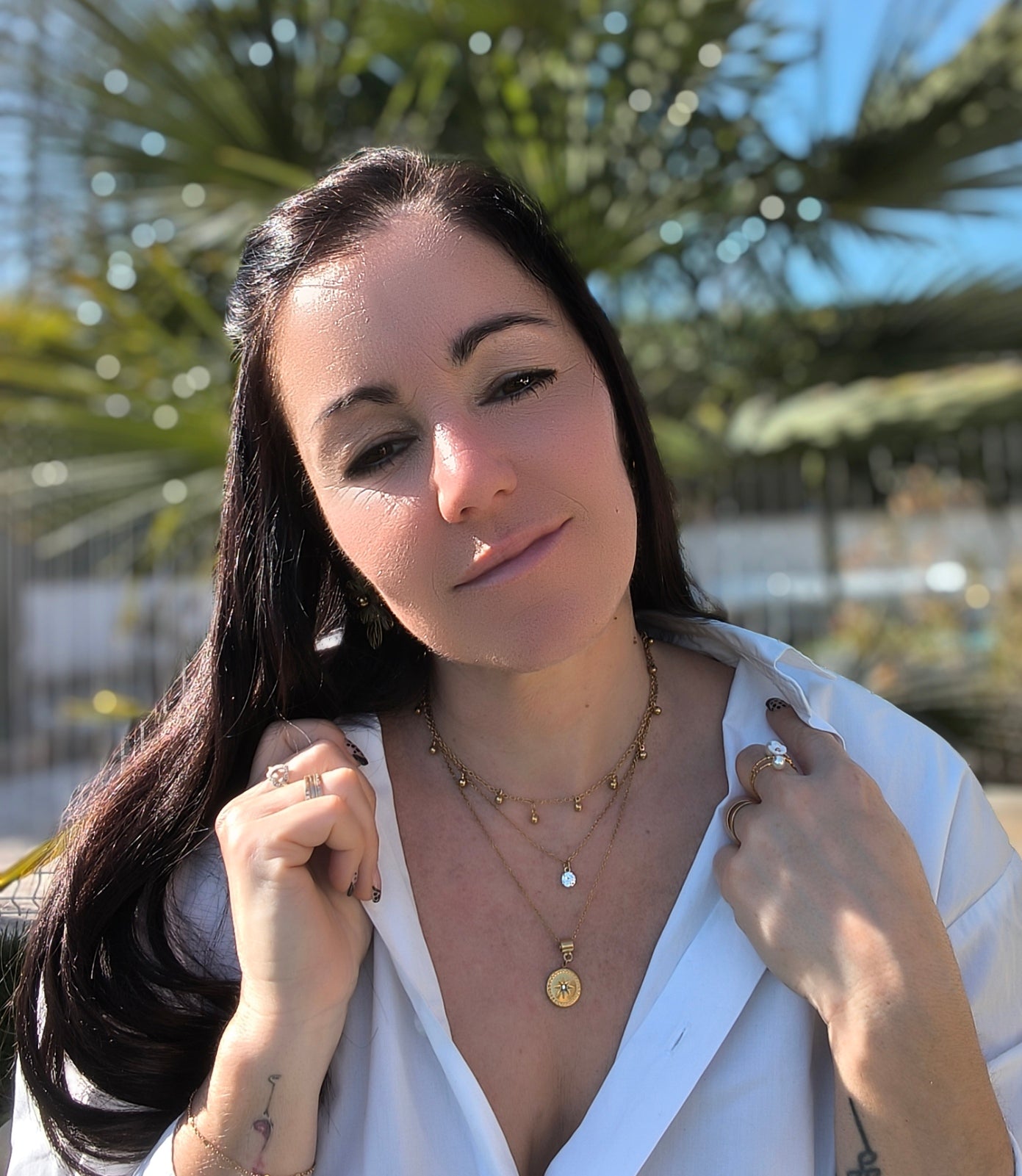 Femme portant Collier triple chaîne avec petites perles dorées pendantes, un pendentif pierre scintillante et un pendentif rond avec une étoile scintillante - Rêve de Rose