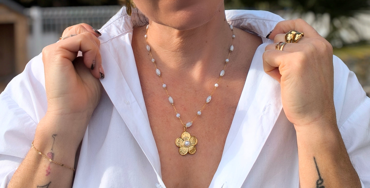 Femme portant Collier chaîne dorée avec des perles blanches avec un pendentif fleur dorée - Rêve de Rose