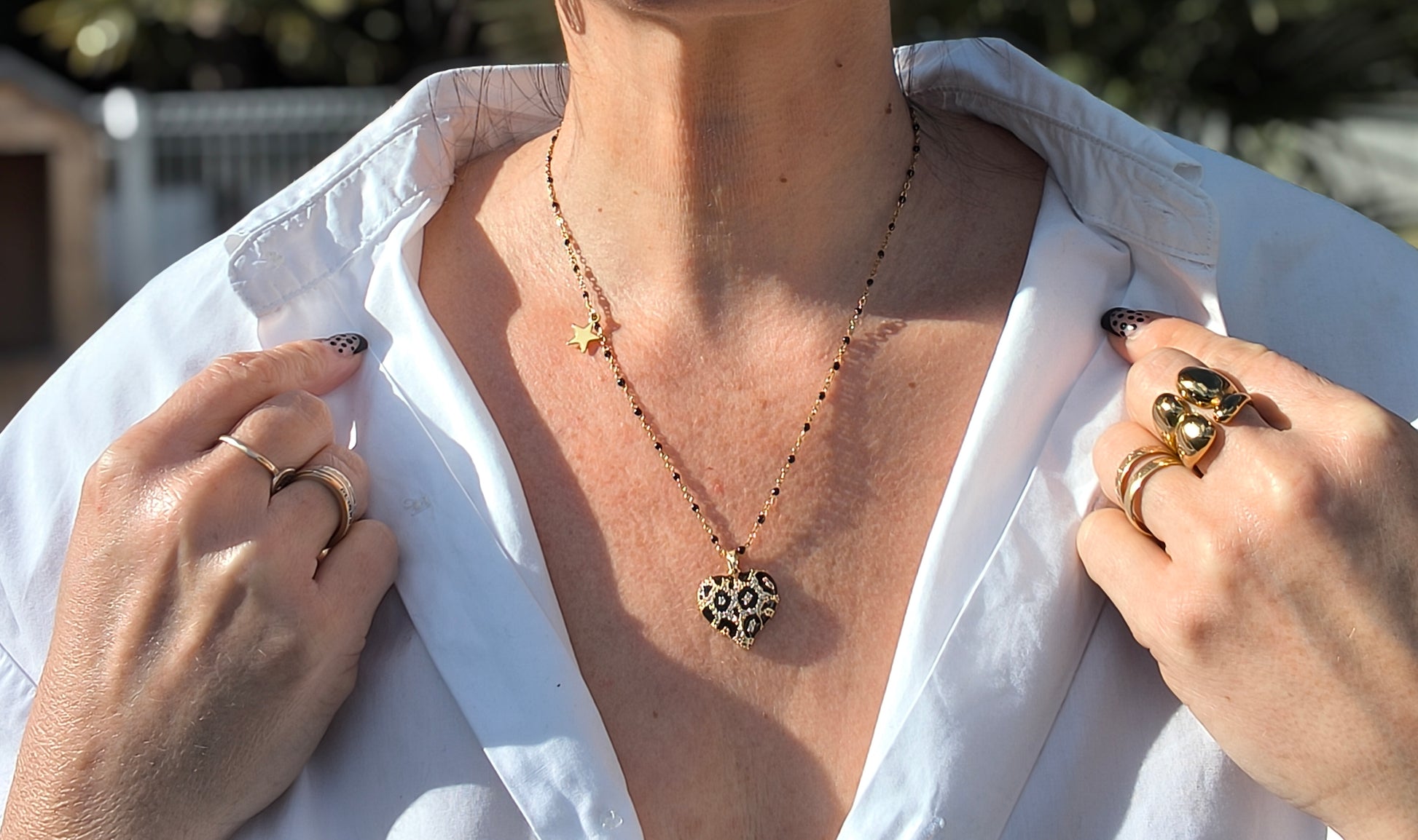 Détails Collier chaîne doré et noire avec un gros cœur noir et doré au motif léopard et un petit pendentif étoile dorée - Rêve de Rose