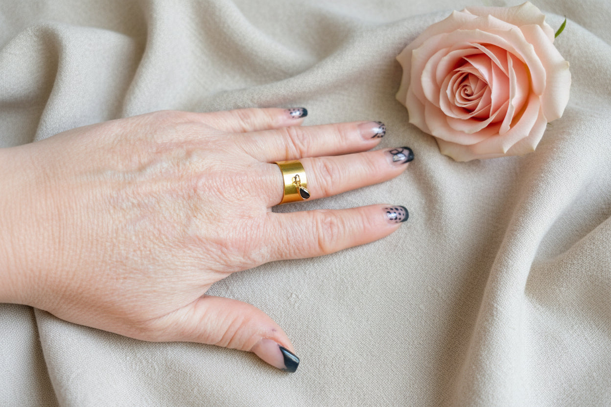 Femme portant Bague ajustable large acier inoxydable doré avec pierre noire - Rêve de Rose