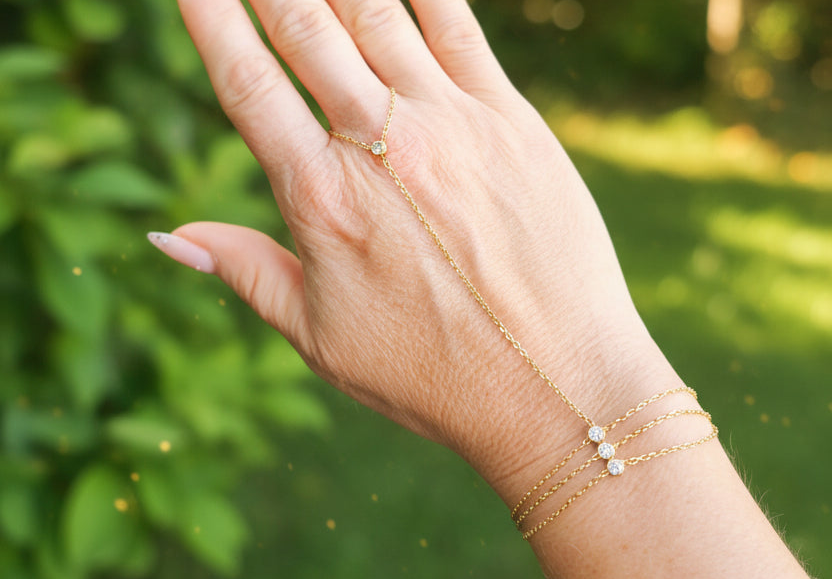 Chaine de main en acier inoxydable doré avec 4 zirconium et bracelet triple chaine porté sur une main