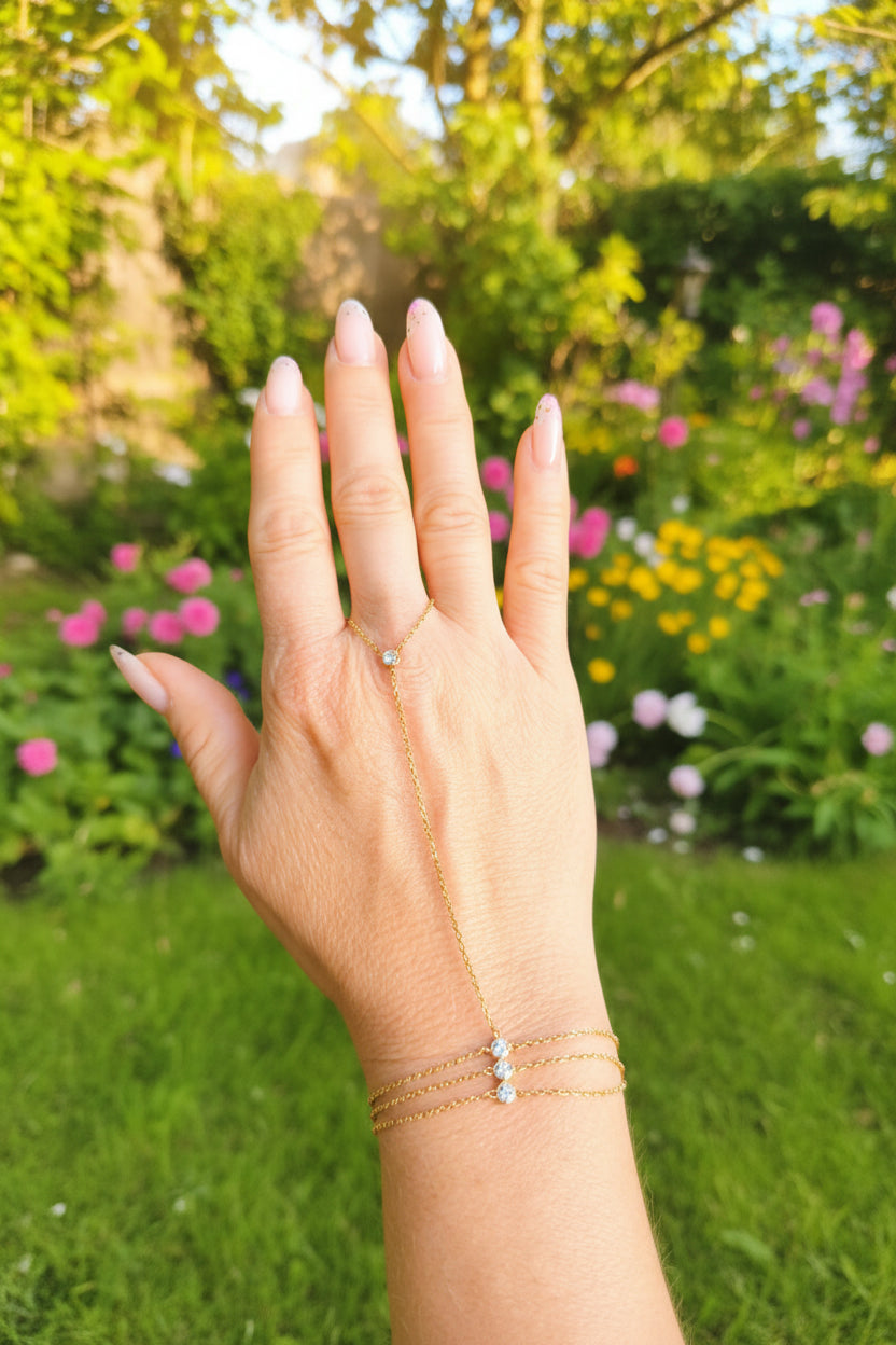 Chaine de main en acier inoxydable doré avec 4 zirconium et bracelet triple chaine porté sur une main
