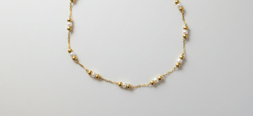 Détail chaîne de cheville perles blanches et perles dorées acier inoxydable – Rêve de Rose