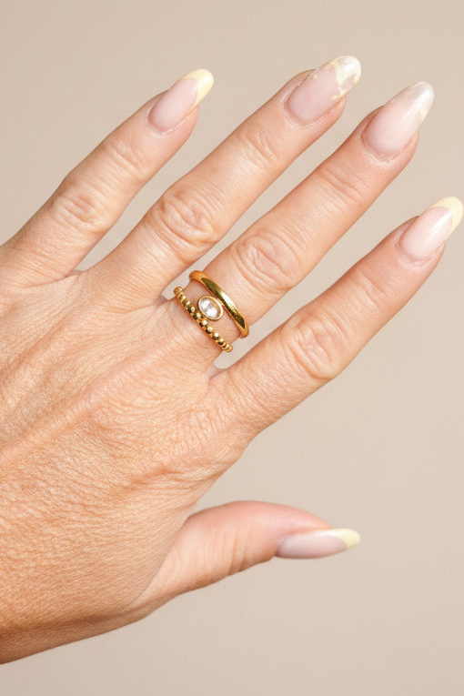 Détail double anneau acier doré rang perlé et martelé encadrant cristal ovale – bague élégante ajustable Rêve de Rose