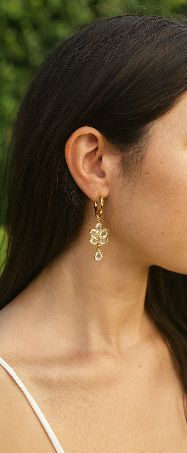 Femme portant Boucles d'oreilles doré pendante avec fleur en pierres scintillantes - Rêve de Rose